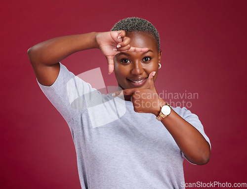 Image of Black woman, face and hands for frame with smile in picture perfect moment against a studio background. African American female smiling with hand sign or frames for photo capture moment on mockup