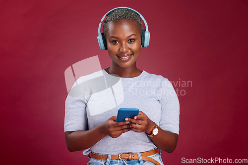 Image of Happy black woman, phone or headphones for music, podcast or listening to radio in red studio background. Smile, wireless earphones of girl for relax audio, smartphone or social media networking