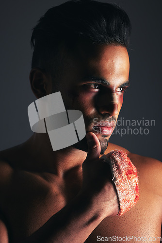 Image of Face, fighting and blood with a man in studio on a gray background ready for a competitive fight. Sports, MMA and boxing with the hand of a young male in a bandage during a brawl or altercation