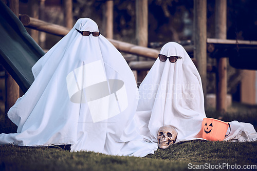 Image of Halloween, glasses and people in ghost costume for trick or treat, global dress up day or fun on playground grass field. Fear fantasy, horror and relax friends role play scary phantom monster at park