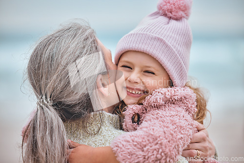 Image of Happy family, beach and mother and child hug, bond or enjoy fun quality time together while relax on ocean sand. Love, peace and outdoor winter freedom for woman, mom or mama with kid girl in nature