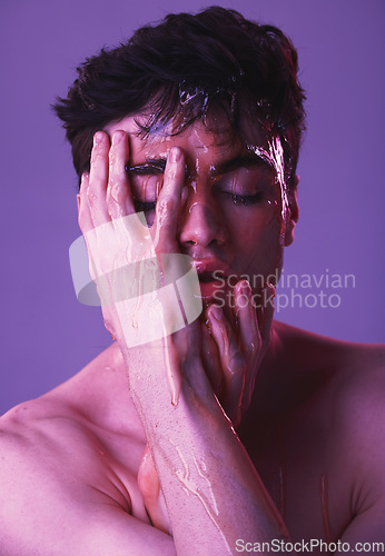 Image of Face, honey and man in studio for skincare, beauty and organic products for facial. Natural beauty products, skincare products and young male model with dripping syrup on hands on purple background