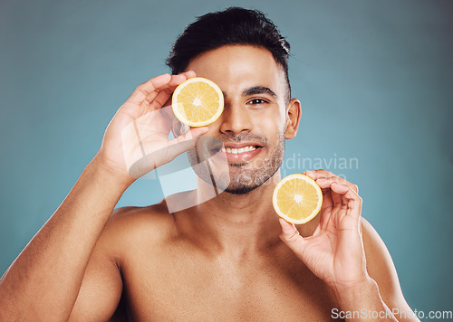 Image of Beauty, man and face, fruit with smile in portrait, grooming and natural cosmetics, skincare advertising with studio background. Indian, citrus and skin with wellness and hygiene, clean and fresh