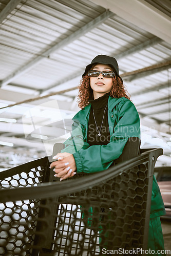 Image of Shopping cart, sunglasses and stylish woman with fashion at a supermarket in the city of Tokyo. Urban, young and portrait of a fashion model shopping with designer, trendy and lifestyle clothes