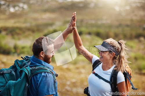 Image of Couple, high five and hiking with motivation, goal and celebration for fitness target in nature with backpack. Man, woman and happy for partnership, excited or support while trekking together outdoor