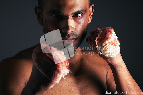 Image of Man, face and blood fist fight with first aid bandages for fighting injury after boxing match. Angry mma athlete boxer, strong bloody hands and fight stand for sports competition in dark background