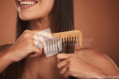 Image of Woman combing hair, closeup smile and cosmetic face beauty for model with orange studio background. Hair care health, happy cosmetic girl and wood recycle comb for wellness with natural healthy locks