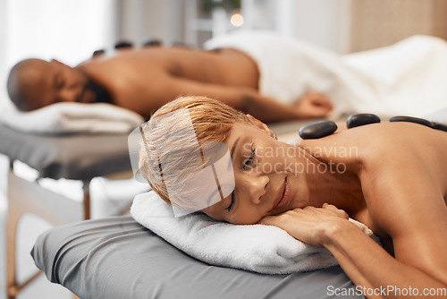 Image of Spa, couple and hot stone massage in wellness, health and beauty salon for pamper, stress relief and pamper treatment. Spa massage, woman and man relax with peace, zen and rock luxury treatment