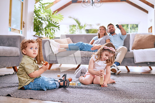 Image of Parents on sofa, children play on floor in home and family time together on weekend morning in Dallas. Streaming movie, young kids bonding with toys and dad searching channel watching tv with mom