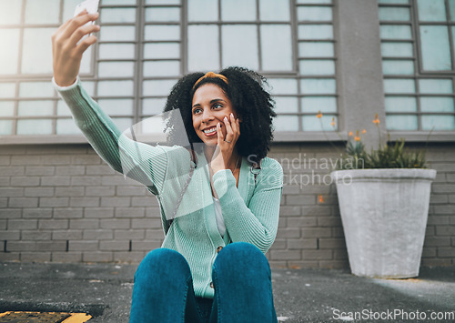 Image of Phone, happy and woman taking a selfie on a street sidewalk outdoors to post online for social media. Smile, student and young girl enjoys taking pictures alone and posting them on a social network