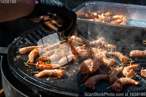 Image of A professional cook prepares shrimps