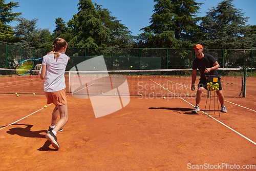 Image of A professional tennis player and her coach training on a sunny day at the tennis court. Training and preparation of a professional tennis player