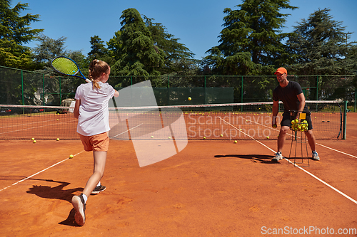 Image of A professional tennis player and her coach training on a sunny day at the tennis court. Training and preparation of a professional tennis player