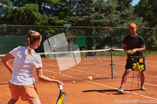 Image of A professional tennis player and her coach training on a sunny day at the tennis court. Training and preparation of a professional tennis player