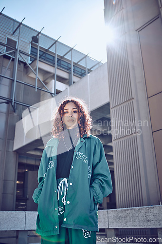 Image of City, urban fashion and portrait of woman in streetwear with buildings and sun in background. Cool hip hop street style, girl from Puerto Rico with serious face and youth on outdoor summer weekend.