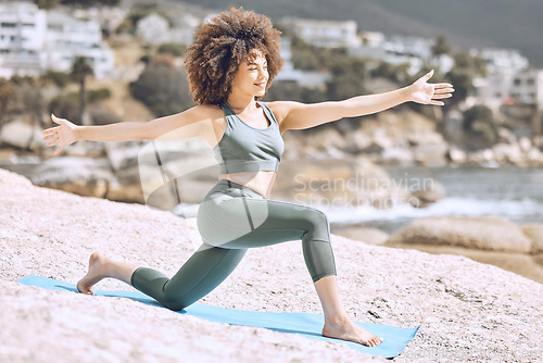 Image of Woman, afro or beach yoga mat for relax stretching, fitness workout or exercise on Brazilian ocean, sea or water rock. Smile, happy or zen yogi in pilates training for mental health or body wellness