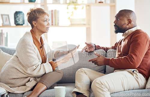 Image of Marriage problem, argument and couple on sofa angry and talking about finance, home mortgage loan or a serious decision. Communication, family law and talking of black people with divorce discussion