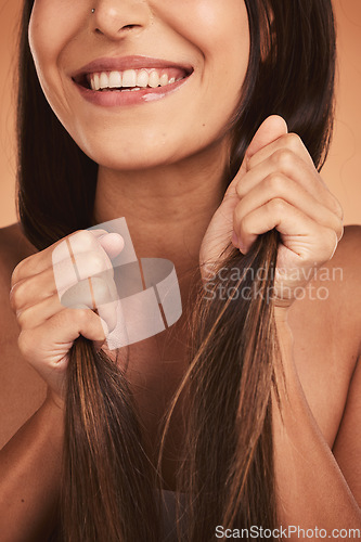 Image of Hands, hair and beauty with a model woman holding her hairstyle in studio on a beige background for keratin treatment. Salon, luxury and cosmetics with a female posing to promote a haircare product