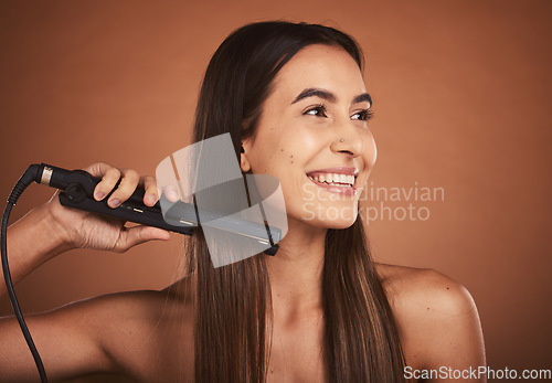 Image of Flat iron woman, hair care studio and beauty cosmetics with smile against brown background. Hair health happiness, hairdresser cosmetic girl and happy hairstyle for wellness self care, tech and heat