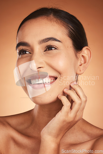 Image of Skincare, makeup and woman thinking of cosmetics for face against a brown studio background. Spa, wellness and girl model with an idea for cosmetic, care for skin and facial beauty with a smile