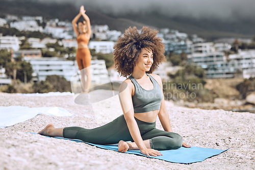 Image of Yoga, fitness and beach with a black woman athlete on a rock by the ocean for a workout or exercise. Nature, summer and health with a happy female yogi training for wellness, zen or mental health