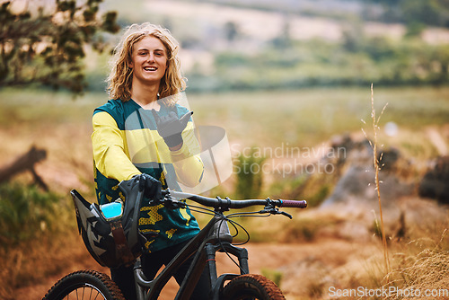 Image of Sports, bike and cyclist man hand sign in nature on a park trail with a smile. Portrait of an adventure athlete on a bicycle ready for cycling, sport and fitness in a mountain park road in nature