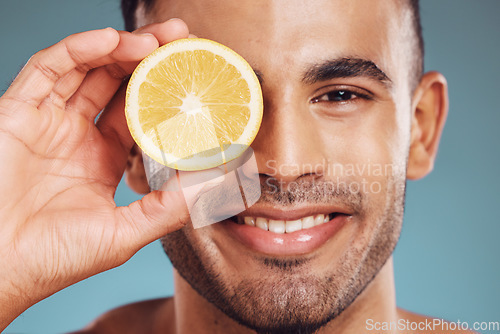 Image of Skincare, lemon and man in face portrait in a studio for facial wellness, healthy glow or cosmetics advertising. Young beauty model smile with vitamin c fruit for dermatology product ingredient