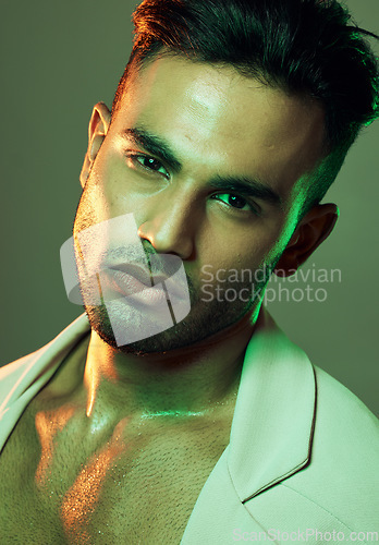 Image of Fashion, green lights and portrait of sexy man from India in studio background creative shoot. Beauty, neon light and professional male model, Indian man and serious face in mens health and cosmetics