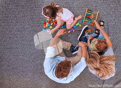 Image of Family, children and learning with education toys, blocks and abacus for color game with mom and dad on floor. Man and women parents with kids for learning, development and playing on home carpet