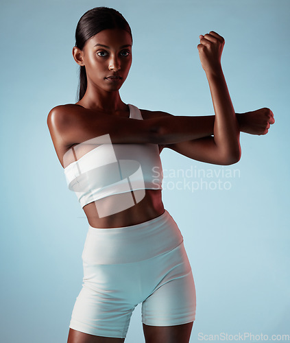 Image of Fitness, body and stretching black woman in studio for exercise, workout or wellness lifestyle portrait with mock up advertising or marketing. Young sports woman with training fashion on blue mockup