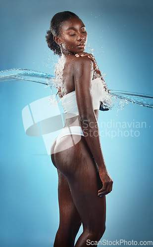 Image of Beauty, water splash and skincare, black woman in underwear, blue background in studio. Fashion, health and fresh clean water for woman with healthy mindset, lifestyle body positivity in South Africa
