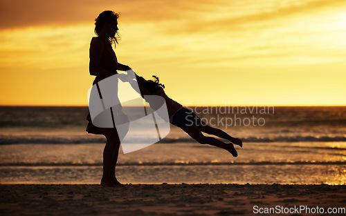 Image of Family, silhouette and sunset at beach with mother swinging child against yellow sky with love, care and support on vacation in summer. Woman and kid by sea for travel fun, adventure and freedom