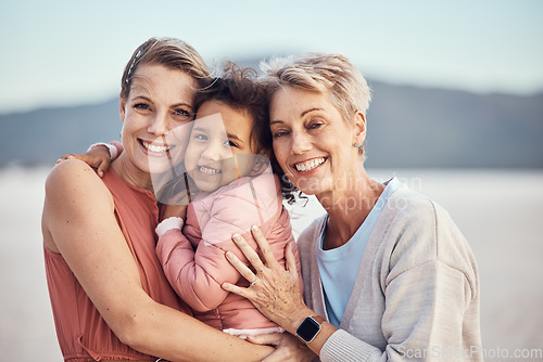 Image of Happy family generation, beach hug and portrait of grandmother, mother and adoption child bonding, relax and enjoy quality time together. Winter peace, freedom and family love of grandma, mom and kid