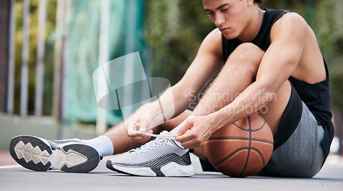 Image of Basketball player, shoes and sports in preparation for game, match or fitness on the court outdoors. Man on basketball court tying shoe laces getting ready or prepare for exercise or training workout