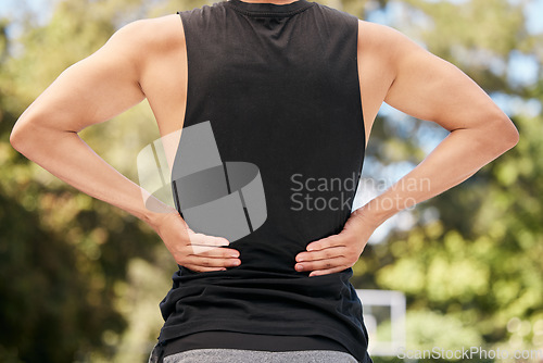 Image of Athlete with back pain, injury or accident from sports match or training on an outdoor court. Fitness, basketball and man with muscle sprain, hurt spine or medical emergency after workout or exercise