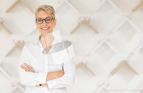 Image of Portrait, glasses and vision with a woman optometrist standing arms crossed alone in her optometry store. Ophthalmology, eyewear and frame with a mature female optician selling frame lenses