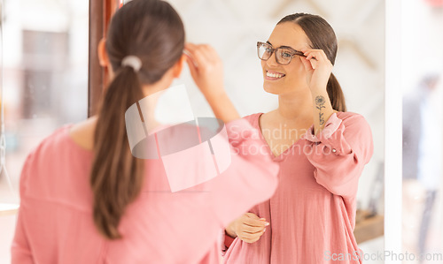 Image of Woman, glasses and mirror at optometrist, new frame and lense for vision, eye and eyesight after shopping in store. Customer choosing, buying and decide for frames for better vision and healthcare