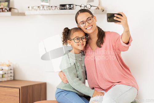 Image of Mother, girl and phone selfie at optometrist, glasses and smile for eye vision, eyesight and social media picture for new lense frame. Woman, child and happy with eyeglasses or 5g mobile smartphone