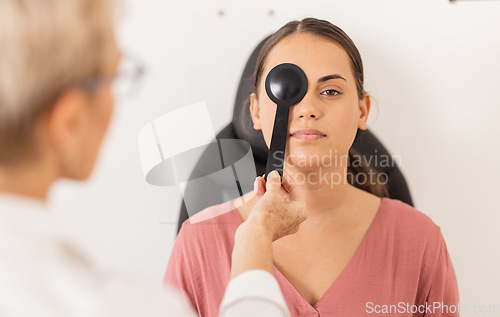 Image of Woman, eye exam and vision test with occluder at optometrist for eyesight, glasses or checkup at the clinic. Doctor optician helping female patient eyes for optical sight in examination or testing