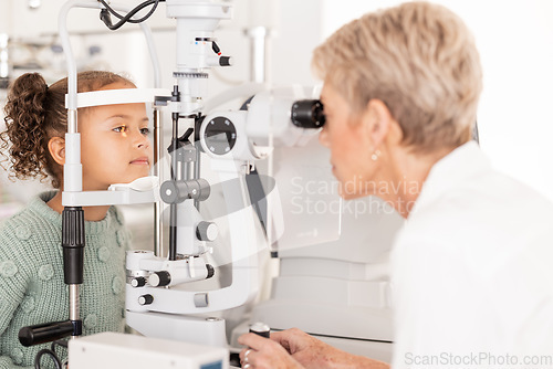 Image of Optometry, vision and optometrist doing eye test on girl for optical care, wellness and health. Senior optician doing optic examination on child with autorefractor equipment in eyewear clinic or shop