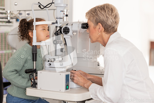 Image of Optometrist doing a vision test on girl at an optical, eyewear and optician store with a autorefractor. Eye care, equipment and child getting eye exam from a senior medical optician at optical clinic