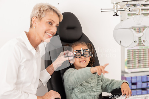 Image of Child, eye exam and ocular health with ophthalmologist doing vision test for glasses during consultation. Happy girl with eye care optometry specialist woman helping patient for wellness and health