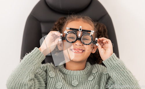 Image of Vision, eye exam and girl with trial lens for prescription spectacles at optometry shop. Eyewear, eyesight test and happy child trying new optical lenses for optic health, wellness and care in clinic