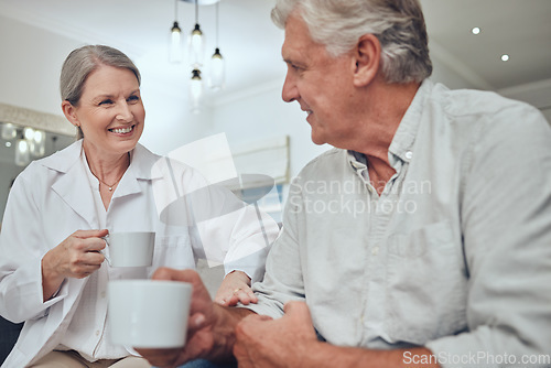 Image of Coffee, morning and love with a senior couple drinking a beverage together in the living room of their retirement home. Tea, relax and talking with a mature man and woman bonding with a drink