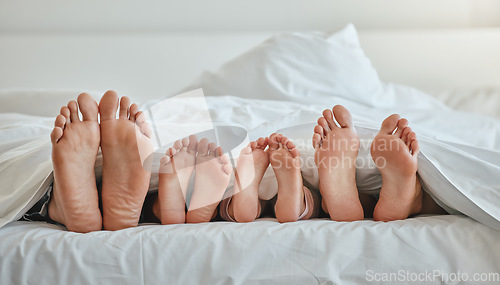 Image of Morning, feet and family sleeping in bedroom for weekend, holiday or nap leisure in house. Relax, mother and dad with young children resting in bed with blanket in family home together.