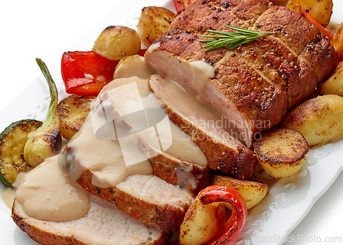 Image of sliced roast pork with vegetables and sauce