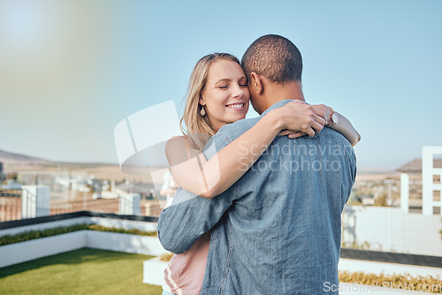 Image of Couple, love and hug on city building rooftop for date, romance and quality time while dancing and happy together. Interracial man and woman on vacation in Cape town in summer for cityscape travel