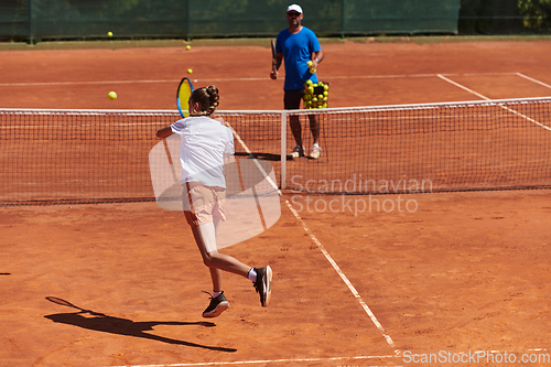 Image of A professional tennis player and her coach training on a sunny day at the tennis court. Training and preparation of a professional tennis player