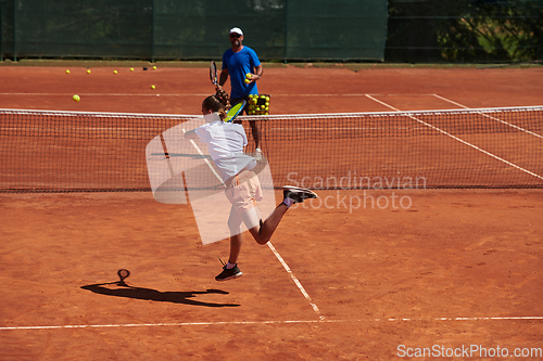 Image of A professional tennis player and her coach training on a sunny day at the tennis court. Training and preparation of a professional tennis player