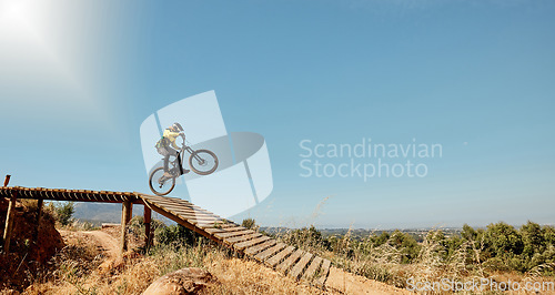 Image of Sports, mountain bike and ramp jump in nature, cycling .and outdoors stunt performance. Fitness, workout and exercise of bmx athlete and racer on bicycle training for competition, race or contest.